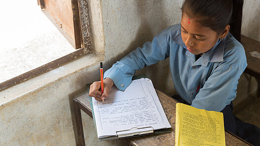 Mädchen in Nepal am schreiben