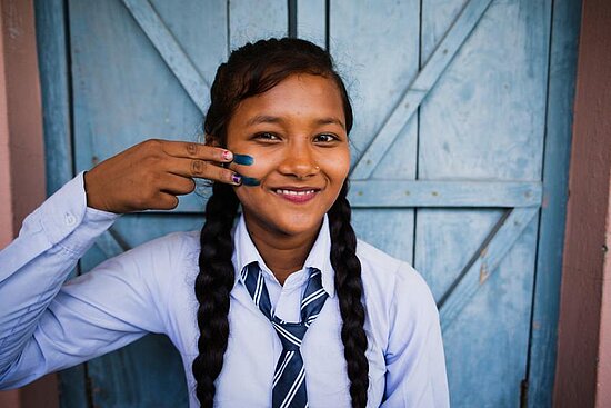 Mädchen in Nepal mit Gleichheitszeichen auf der Wange