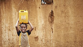 Mädchen aus Afrika trägt Wasser
