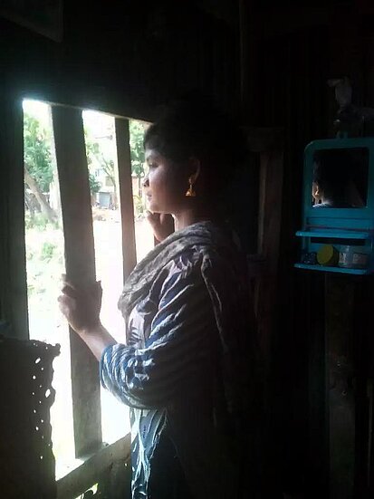 Une fille au Bangladesh regarde par la fenêtre