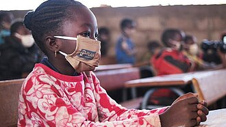 Schülerin mit einer Maske in Burkina Faso