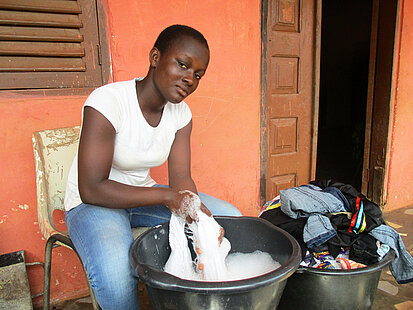 Une fille en train de faire la lessive à la main au Ghana