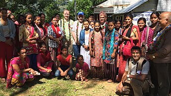 Plan-Mitarbeitende und Frauen in Nepal