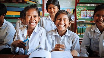 Eine Partnerschaft mit Plan International Schweiz für lachende Kinder Lachende Mädchen in der Grundschule in Siem Rep, Kambodscha