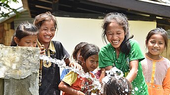 Des filles jouent à côté d'une fontaine en Asie