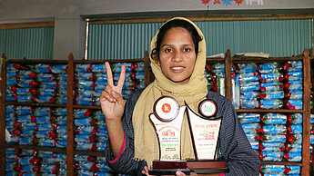 Shirin, 22 ans du Bangladesh montre le prix qu'elle a reçu pour son engagement.