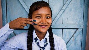 Mädchen in Nepal mit Gleichheitszeichen auf der Wange