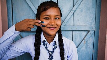 Mädchen in Nepal mit Gleichheitszeichen auf der Wange
