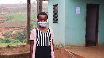 Mädchen mit einer Gesichtsmaske aus Kamerung